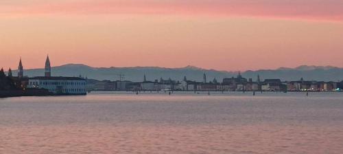 a view of a city from the water at sunset at Views on Venice Lagoon in Lido