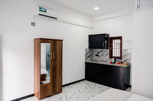 a kitchen with a wooden door in a room at Transit Heaven - 10 Minutes to Airport in Katunayake