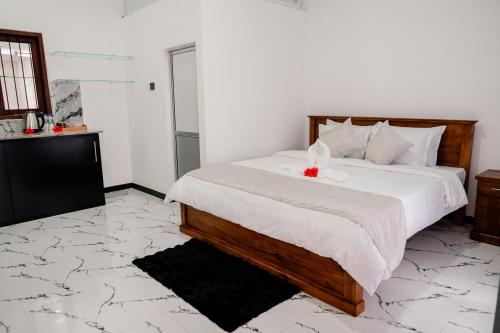 a bedroom with a bed with a red flower on it at Transit Heaven - 10 Minutes to Airport in Katunayake