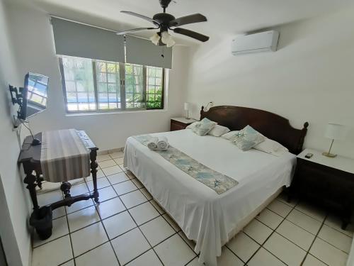 カンクンにあるCozy house downtown Cancunのベッドルーム1室(ベッド1台、椅子、シーリングファン付)