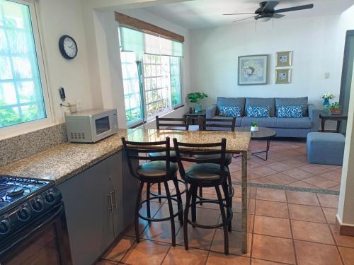 a kitchen and living room with a counter and stools at Cozy house downtown Cancun in Cancún