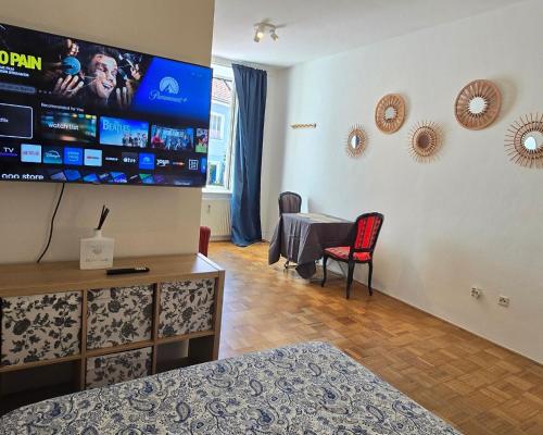 a room with a tv and a table and chairs at Mi Casa Apartment 11 in Graz