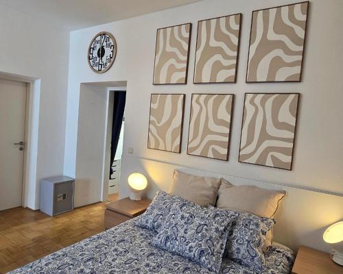 a bedroom with a bed and a clock on the wall at Mi Casa Apartment 11 in Graz
