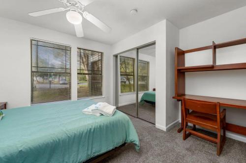 a bedroom with a bed and a desk and windows at Pool Gym & Extended Stays Budget Frienly in Tampa