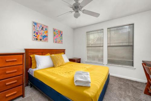 a bedroom with a yellow bed and a ceiling fan at Pool Gym & Extended Stays Budget Frienly in Tampa