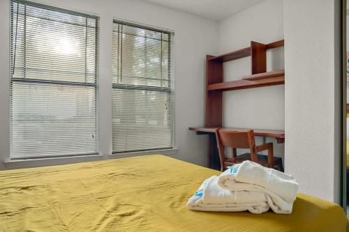 a bedroom with a yellow bed with a desk and window at Pool Gym & Extended Stays Budget Frienly in Tampa