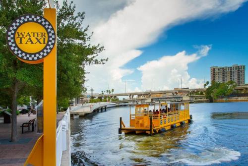 a yellow boat on a river near a bridge at Pool Gym & Extended Stays Budget Frienly in Tampa