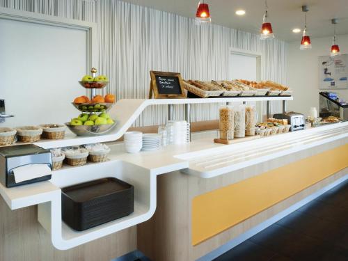a bakery counter with pastries and other food items at ibis Budget Brussels South Ruisbroek in Ruisbroek