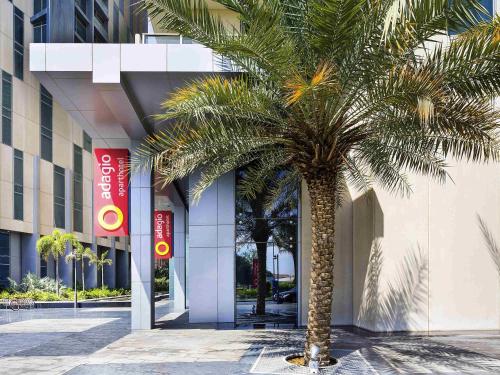 a palm tree in front of a building at Adagio Abu Dhabi Al Bustan in Abu Dhabi