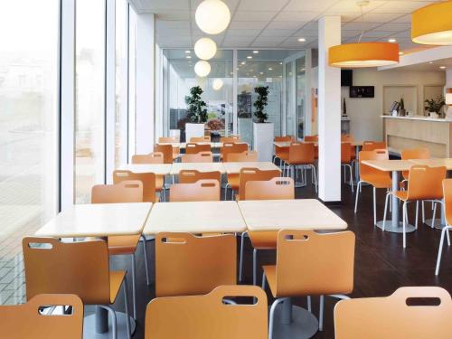 a classroom with tables and chairs in an office at ibis Budget Brussels South Ruisbroek in Ruisbroek
