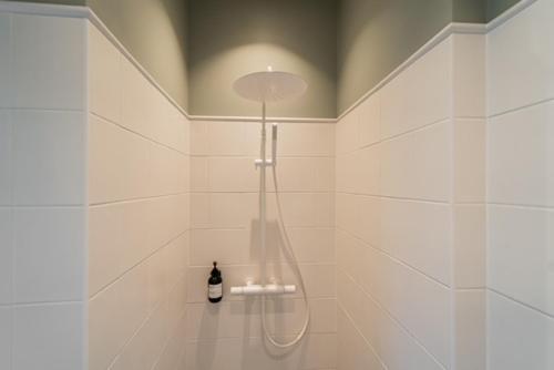 a bathroom with a shower with a bottle of wine at Stylish Apartment in Historic Villa Doll, City Center in Viljandi