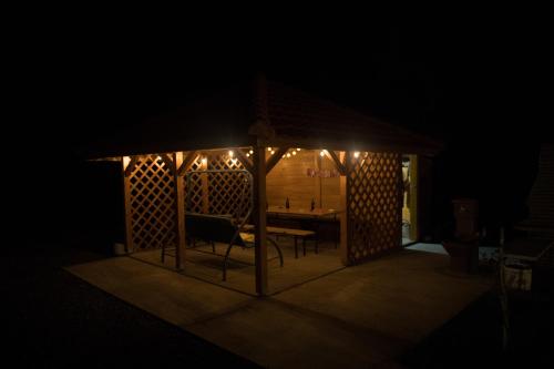 a gazebo with a table and chairs in the dark at Sunny Apartments in Malo Laole