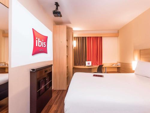 a hotel room with a big bed and a desk at ibis Santiago Las Condes in Santiago