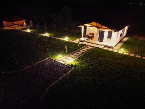 a small cabin with lights in a yard at night at Sunny Apartments in Malo Laole