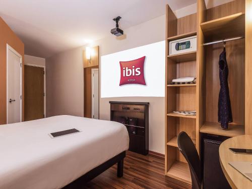 a room with a bed with a sign on the wall at ibis Santiago Las Condes in Santiago