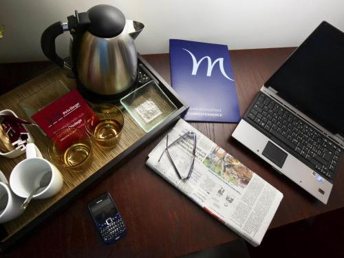 a wooden table with a laptop computer and a book at Mercure Olbia in Olbia
