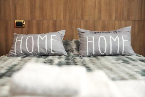 a bed with two pillows with the home written on them at Residenza Sant'Andrea in Campobasso