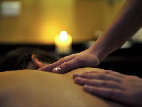 a woman getting a back massage with her hands on her back at Mercure Olbia in Olbia