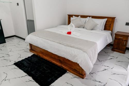a bedroom with a bed with a red flower on it at Transit Heaven - 10 Minutes to Airport in Katunayake