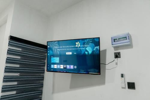 a flat screen tv hanging on a wall at Transit Heaven - 10 Minutes to Airport in Katunayake