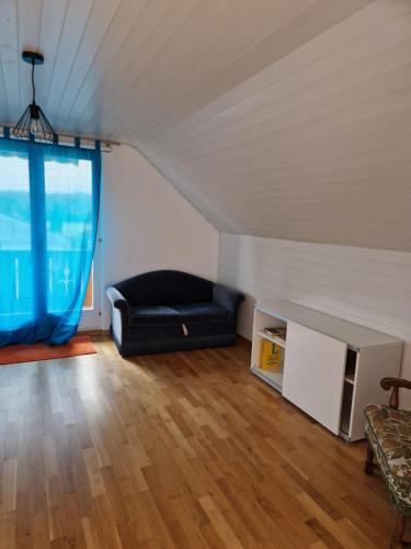 a living room with a black couch in a attic at Ferienwohnung Pirol in Grenchen