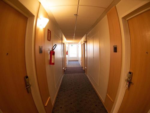 a long hallway with a fire extinguisher in a building at ibis Contagem Ceasa in Contagem