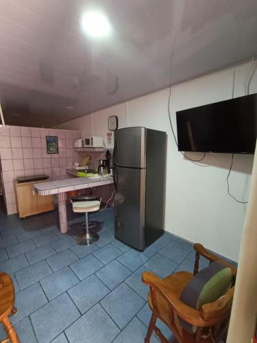 a kitchen with a refrigerator and a counter with a table at Apartamentos Novoa in San José
