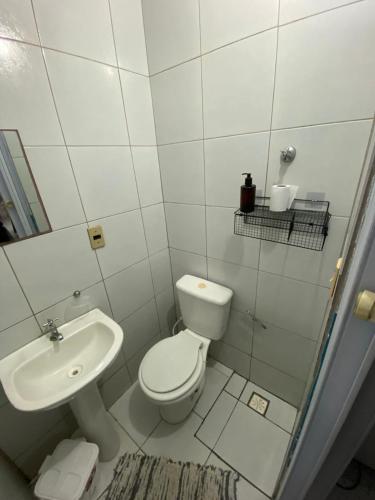 a white bathroom with a toilet and a sink at FLAT ZONA NORTE NATAL PRÓX PRAIA GENIPABU ou shopping partage in Natal