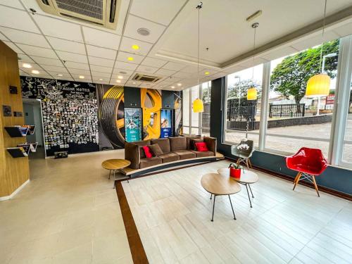 a lobby with a couch and some tables and chairs at ibis Ourinhos in Ourinhos