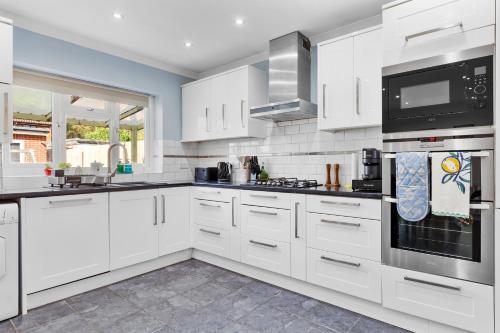 a white kitchen with white cabinets and appliances at The Aviator Heathrow in Harmondsworth