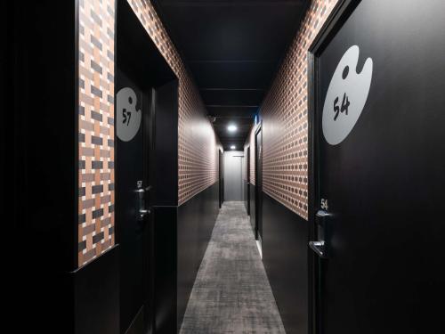 a hallway with two doors and a brick wall at ibis Styles Paris Cadet Lafayette in Paris