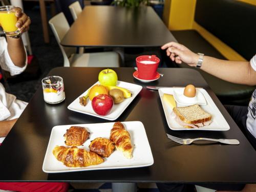 a table with two plates of food on it at ibis Styles Paris Cadet Lafayette in Paris
