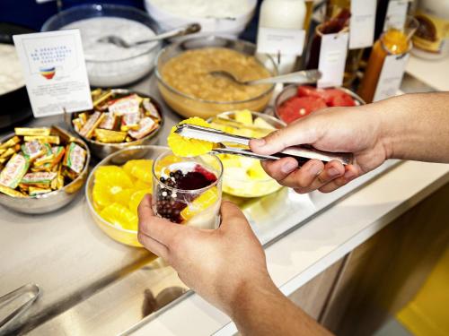 a group of people serving food at a buffet at ibis Styles Paris Cadet Lafayette in Paris