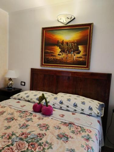 a bedroom with a bed with a painting on the wall at Il Ciliegio di Lurisia in Lurisia