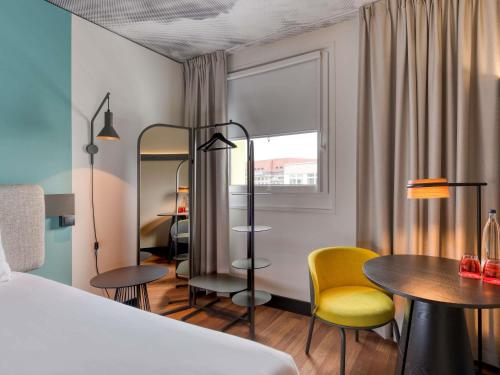 a hotel room with a bed and a table and chairs at ibis Berlin Kurfuerstendamm - neu renoviert in Berlin
