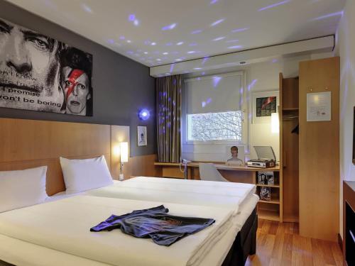 a hotel room with a large bed and a desk at ibis Berlin Kurfuerstendamm - neu renoviert in Berlin