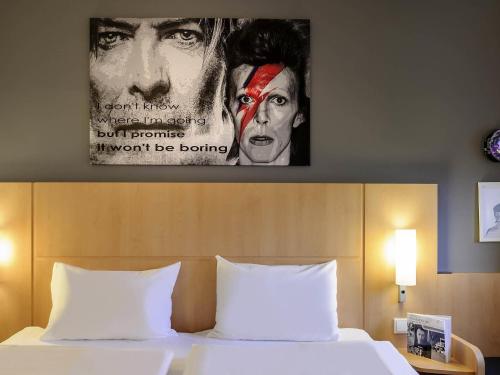 a poster of a movie hanging above a bed at ibis Berlin Kurfuerstendamm - neu renoviert in Berlin