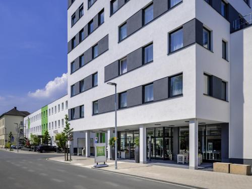 a large white building on a city street at ibis Styles Arnsberg - Neheim in Arnsberg