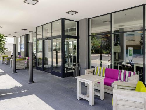 a store front with a purple couch and a table at ibis Styles Arnsberg - Neheim in Arnsberg
