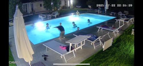 a group of people in a swimming pool at night at Dimora S'Ena Manna in Oliena