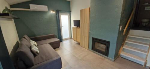 a living room with a couch and a fireplace at Casa Cool - Climatisation réversible et Nature in Virton