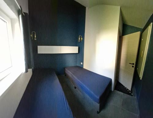 a room with a blue bed in a room at Casa Cool - Climatisation réversible et Nature in Virton