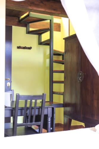 a dining room with a table and a spiral staircase at Residenza Sant'Andrea in Campobasso