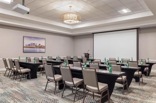 a conference room with tables and chairs and a screen at Hilton Garden Inn Shirlington in Arlington