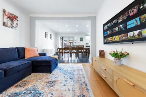 a living room with a blue couch and a dining room at The Aviator Heathrow in Harmondsworth