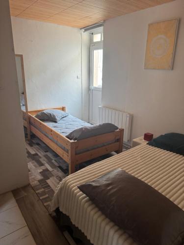 a room with two beds and a window at Arhomeplus-hunic in Autun