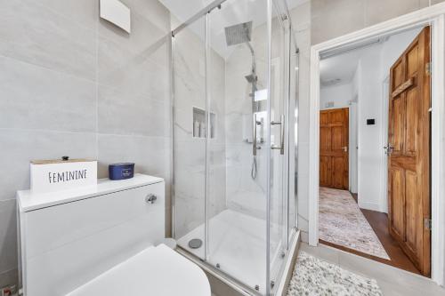 a bathroom with a shower with a glass door at The Aviator Heathrow in Harmondsworth