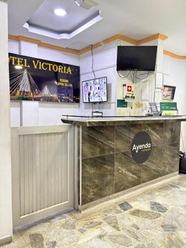 a lobby with a reception counter with a tv on the wall at Ayenda 1122 Victoria in Pereira