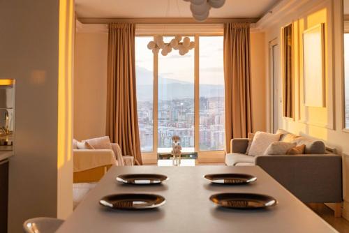 a living room with a table and a large window at Golden-Hour Loft 35F Sunset Views Free Parking in Gorno Lisiče