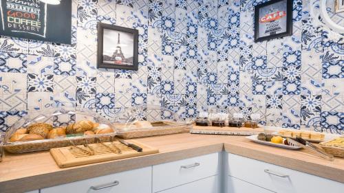a kitchen with blue and white tiles on the wall at Garner Hotel Cologne Porz - Airport by IHG in Cologne